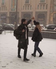 two people are walking in the snow and one is holding his hand out to another person