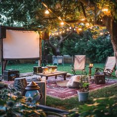 an outdoor movie is set up in the backyard with chairs and lights strung over it