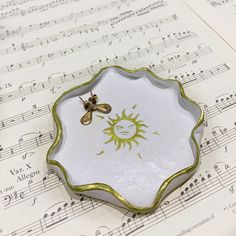 a bee sitting on top of a white plate next to sheet music