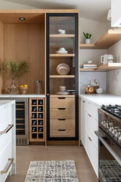 a kitchen with white cabinets and wooden shelves