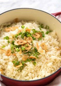 rice with peas and cashews in a red pot on a white tablecloth