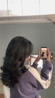 a woman taking a selfie in front of a mirror