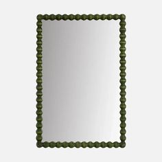 a square mirror with green beading around the edges