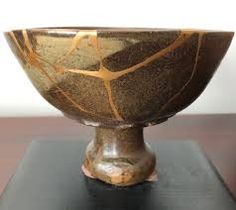 a brown bowl sitting on top of a wooden table next to a white and black wall