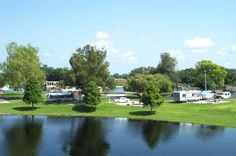 rv park next to a lake with trees in the foreground