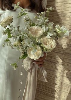 a woman in a white dress holding a bouquet of flowers