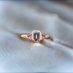 Crafted in 18K yellow gold, this ring features a Light Pink Emerald Cut Sapphire hugged by two kite-shaped Raspberry Pink Trillion Sapphires. Their measurements are as follows: Light Pink Emerald Cut Sapphire: 6.50 x 4.45 x 2.77mm Carat Weight: 0.80ct Raspberry Trillion Side Stones: 2.6 x 2.6mm Carat Weight: 0.11ct each Total Sapphire Carat Weight: 1.02 cttw This ring is currently a size 6.5 (US) but can be sized up or down within tolerance. Please email marena@jewelsbymarena.com followed by a l Ring Marriage, Emerald Cut Sapphire Ring, Fairytale Ring, Pink Topaz Ring, Run The Jewels, Pink Emerald, Pink Sapphire Ring, Raspberry Pink, Dope Jewelry