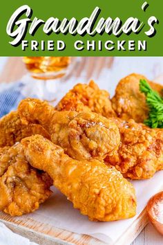 some fried chicken on a white plate with parsley and sauce in the background text reads grandma's fried chicken