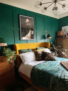 a bedroom with green walls and a yellow headboard is pictured in the foreground