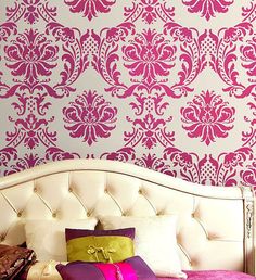 an image of a bed with pink and white wallpaper on the headboard in front of it