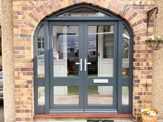 the front entrance to a brick building with double doors and sidelights on either side