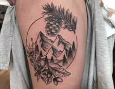 a man with a pine cone tattoo on his thigh and the mountain in the background