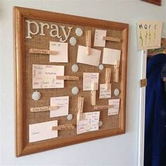 a cork bulletin board with notes and magnets attached to it, hanging on the wall