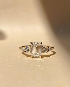 an emerald cut diamond ring with three side stones