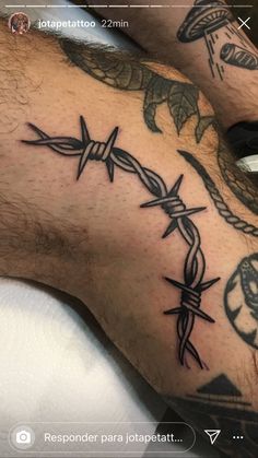 a man's foot with tattoos on it and barbed wire in the middle of his leg