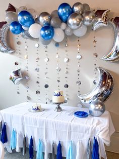 a table topped with balloons and blue tassels