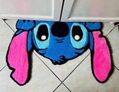 a blue and pink rug with a cartoon dog on it's face next to a cabinet door