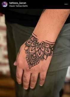 a person's hand with a tattoo on it and a wristband in the shape of a flower