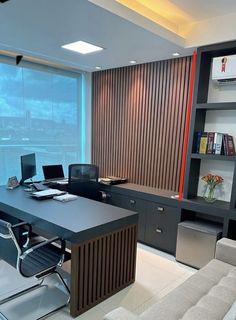 an office with a large desk and chairs in front of a wall mounted bookshelf