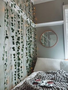 a bed with a blanket on top of it next to a window covered in lights