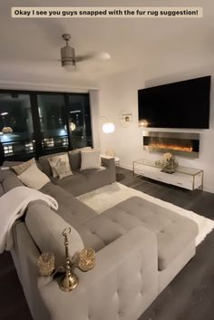 a living room filled with furniture and a flat screen tv mounted to the wall over a fire place