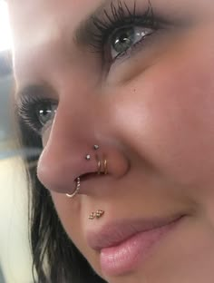 a close up of a person with a nose ring and piercings on her nose