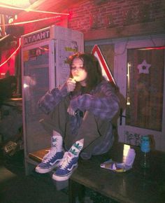 a woman sitting on top of a table next to a vending machine