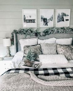 a bed with pillows, blankets and pictures on the wall above it in a bedroom