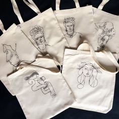 four totes with drawings on them sitting next to each other