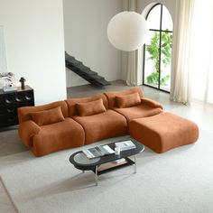 an orange sectional sofa sitting on top of a white rug next to a coffee table