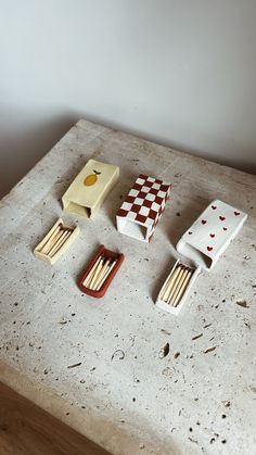 four matches are sitting on a table next to some boxes with matchsticks in them