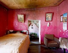 a bed room with a neatly made bed and pictures on the wall next to it