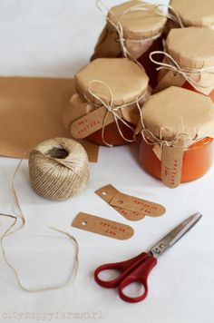 some crafting supplies are sitting on a table with twine, scissors and paper tags