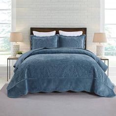 a blue comforter set with white pillows