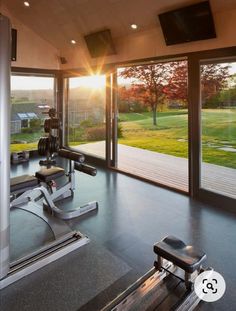 an exercise room with treadmills and sliding glass doors leading out to a grassy field