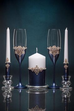 three wine glasses, one with a candle and the other with a candle holder on it