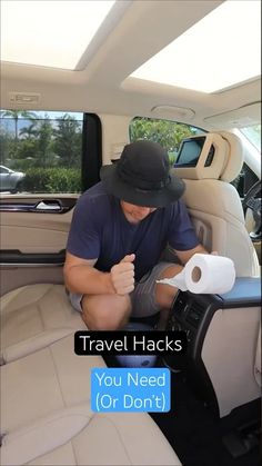 a man sitting in the back seat of a car holding a roll of toilet paper