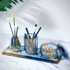 a marble tray with blue glass vases and brushes