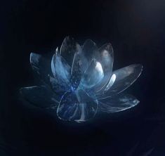 a glass flower sitting on top of a blue table cloth in the middle of a dark room