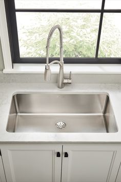 a stainless steel kitchen sink under a window