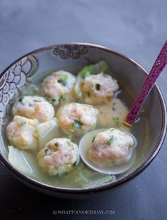 a bowl filled with shrimp and dumplings in broth