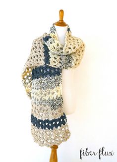 a mannequin wearing a multicolored crocheted scarf on a white background