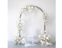 a white wedding arch decorated with flowers