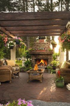 an outdoor living area with wicker furniture and fireplace