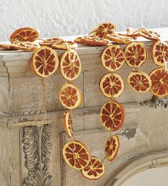 orange slices are hanging from the top of a fireplace mantel with ornate carvings on it