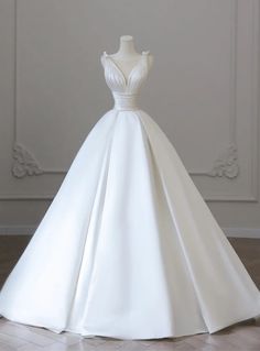 a white wedding dress on display in front of a wall