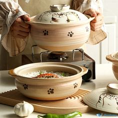 a person preparing food on top of a stove next to bowls and spoons with chopsticks in them