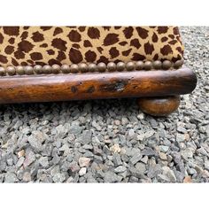 a wooden bench with leopard print upholstered on it's back and legs