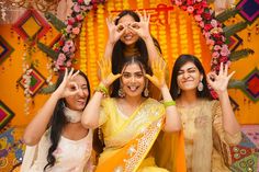 three women posing for the camera with their hands in the air