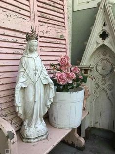 pink roses in a bucket next to a statue